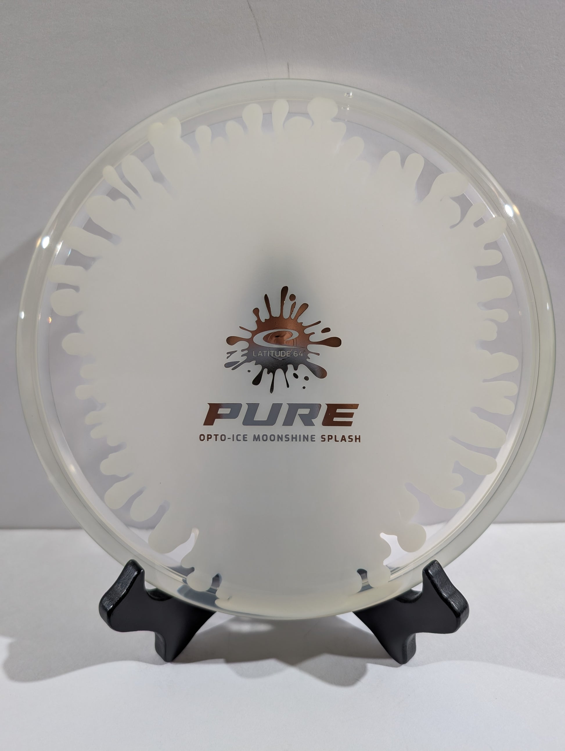 Clear and white disc with 'PURE' branding on a stand against a white background