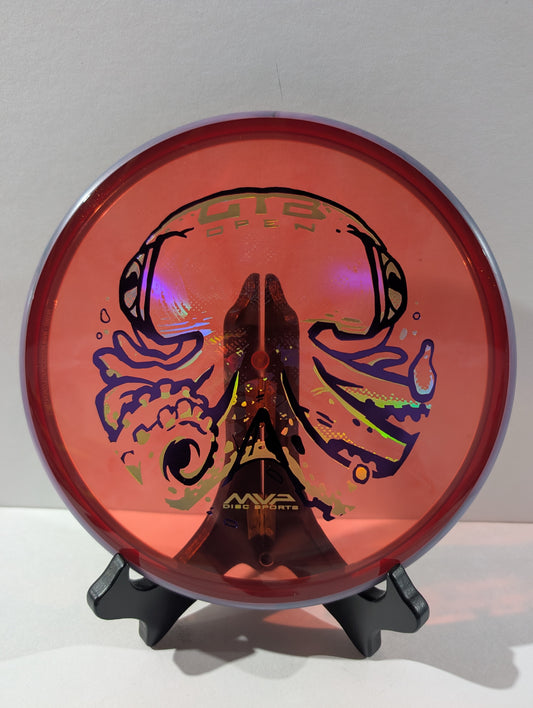 Red disc golf disc with colorful design on a stand against a gray background