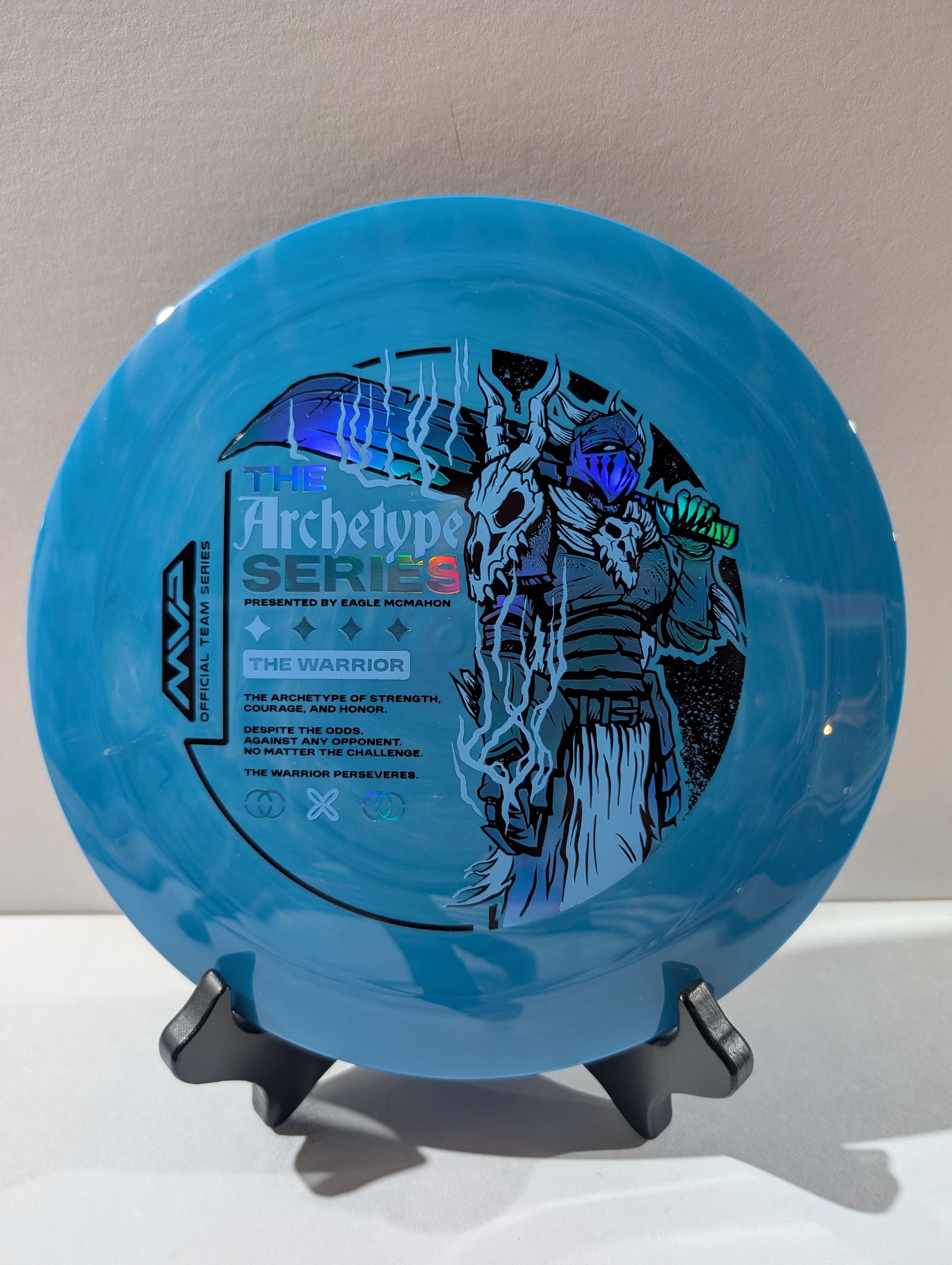 Blue disc with warrior design on a stand against a neutral background