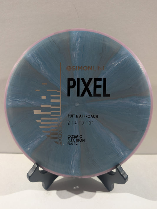 A disc golf disc on a small display stand, featuring a blue and gray marbled pattern with a pink outer rim. The disc is branded with 'Simon Line' and 'Pixel'.