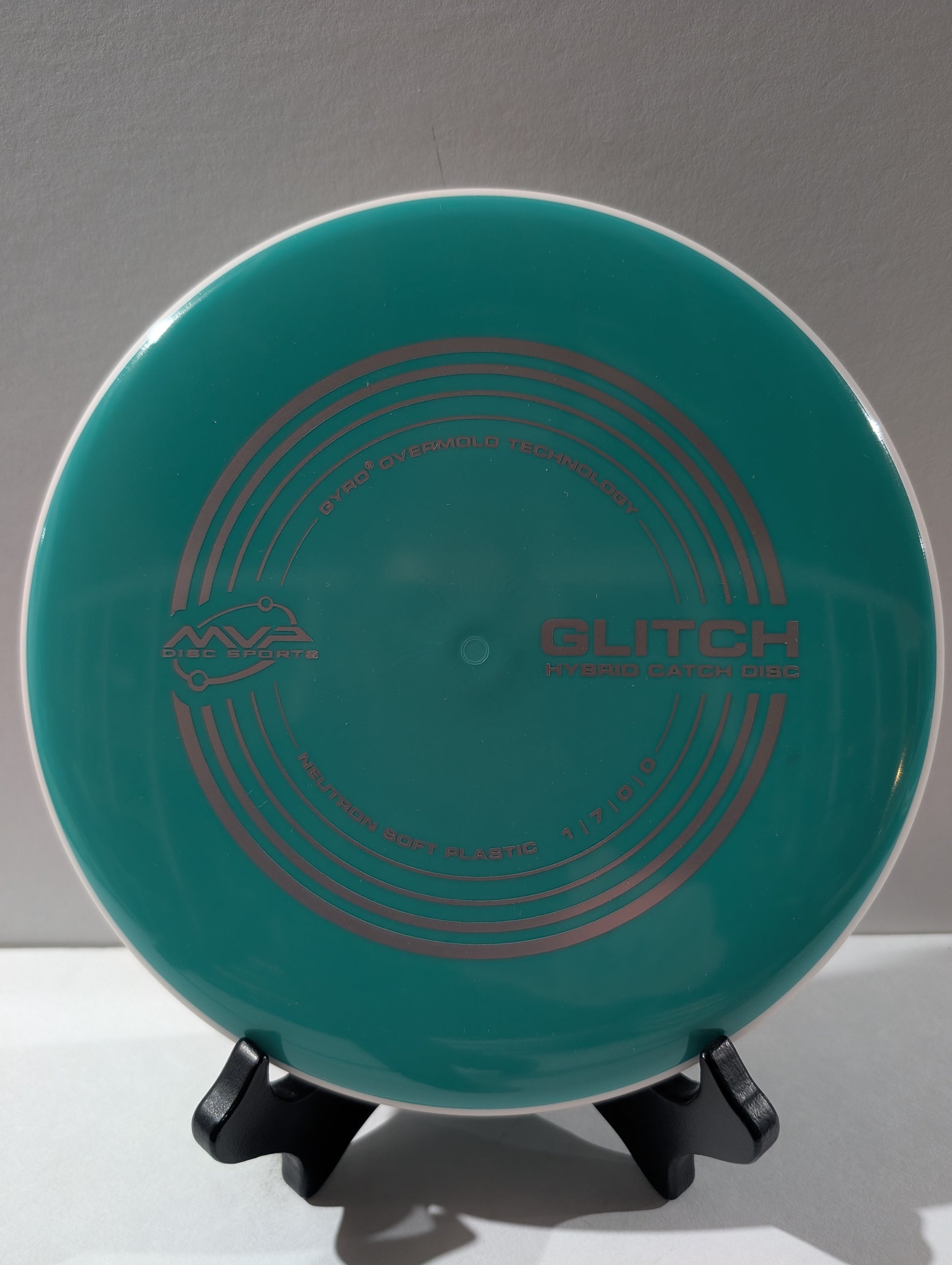 Teal disc with 'Glitch' branding on a stand against a gray background
