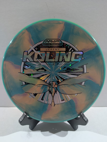 Disc golf disc with dragonfly design and branding on a stand against a white background