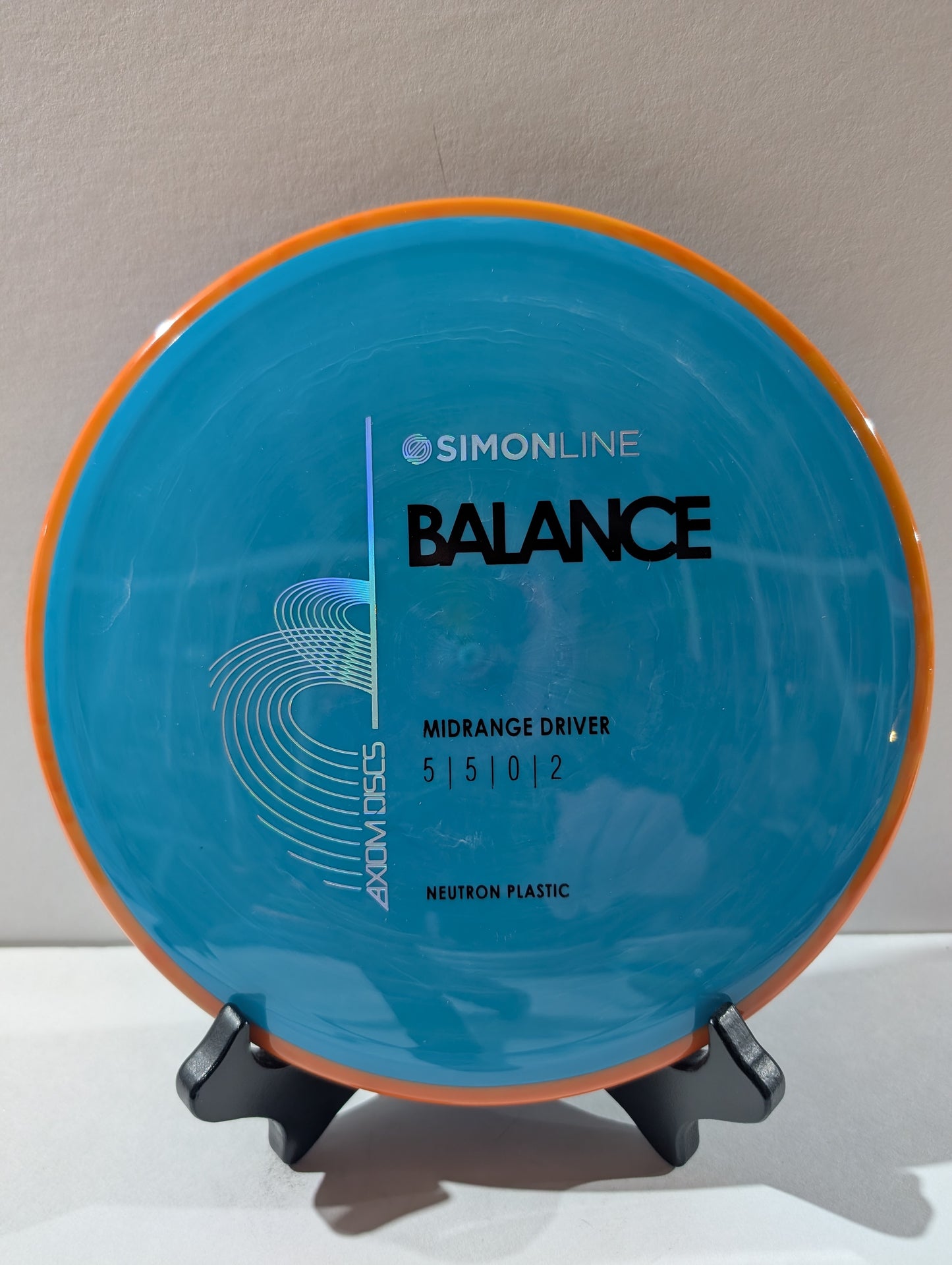Blue disc with orange rim on a stand against a gray background