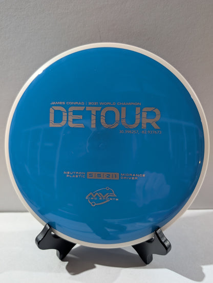 Blue disc golf disc on a stand with branding and text