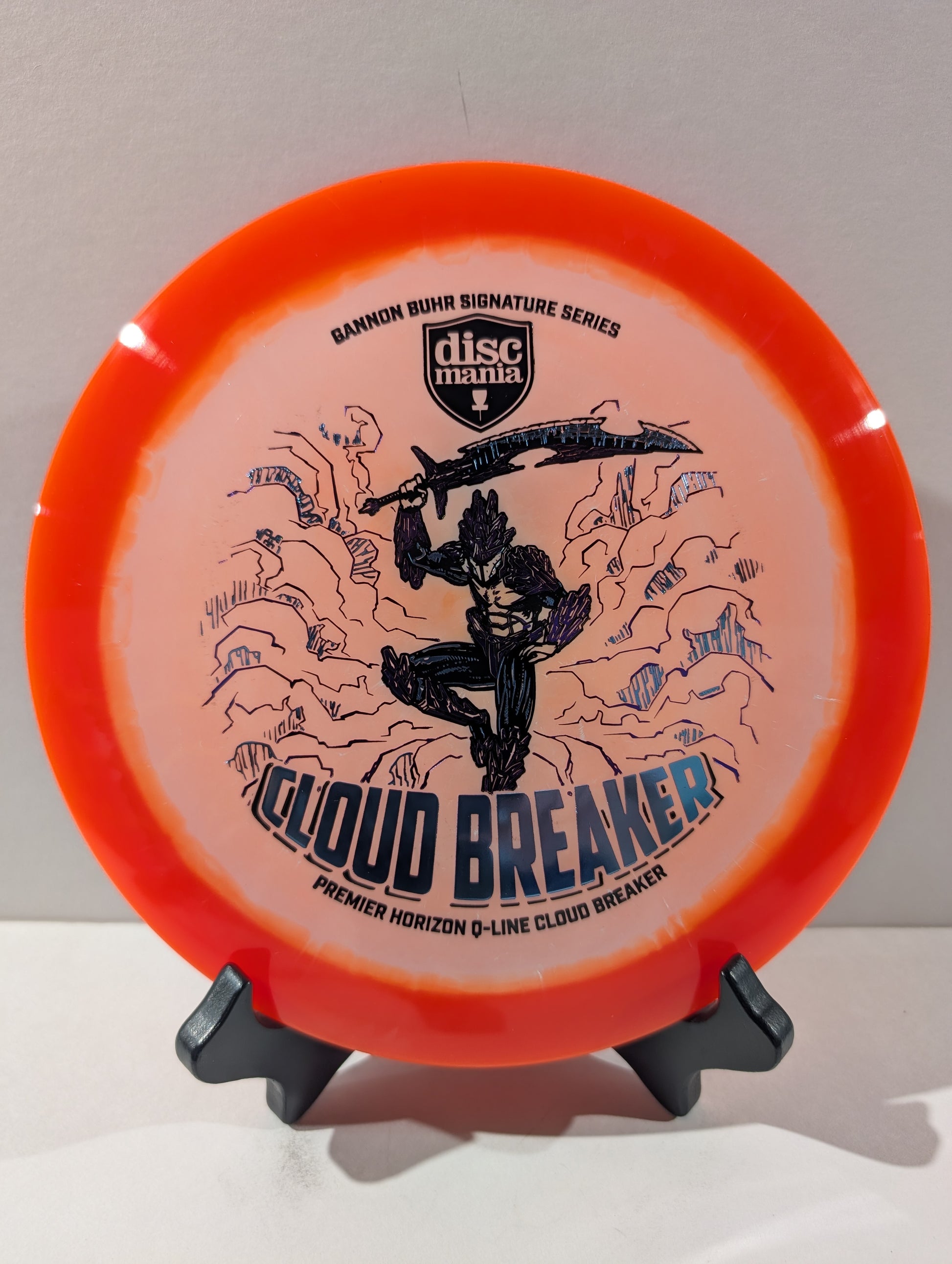 Discmania Cloud Breaker disc golf disc on a stand against a gray background