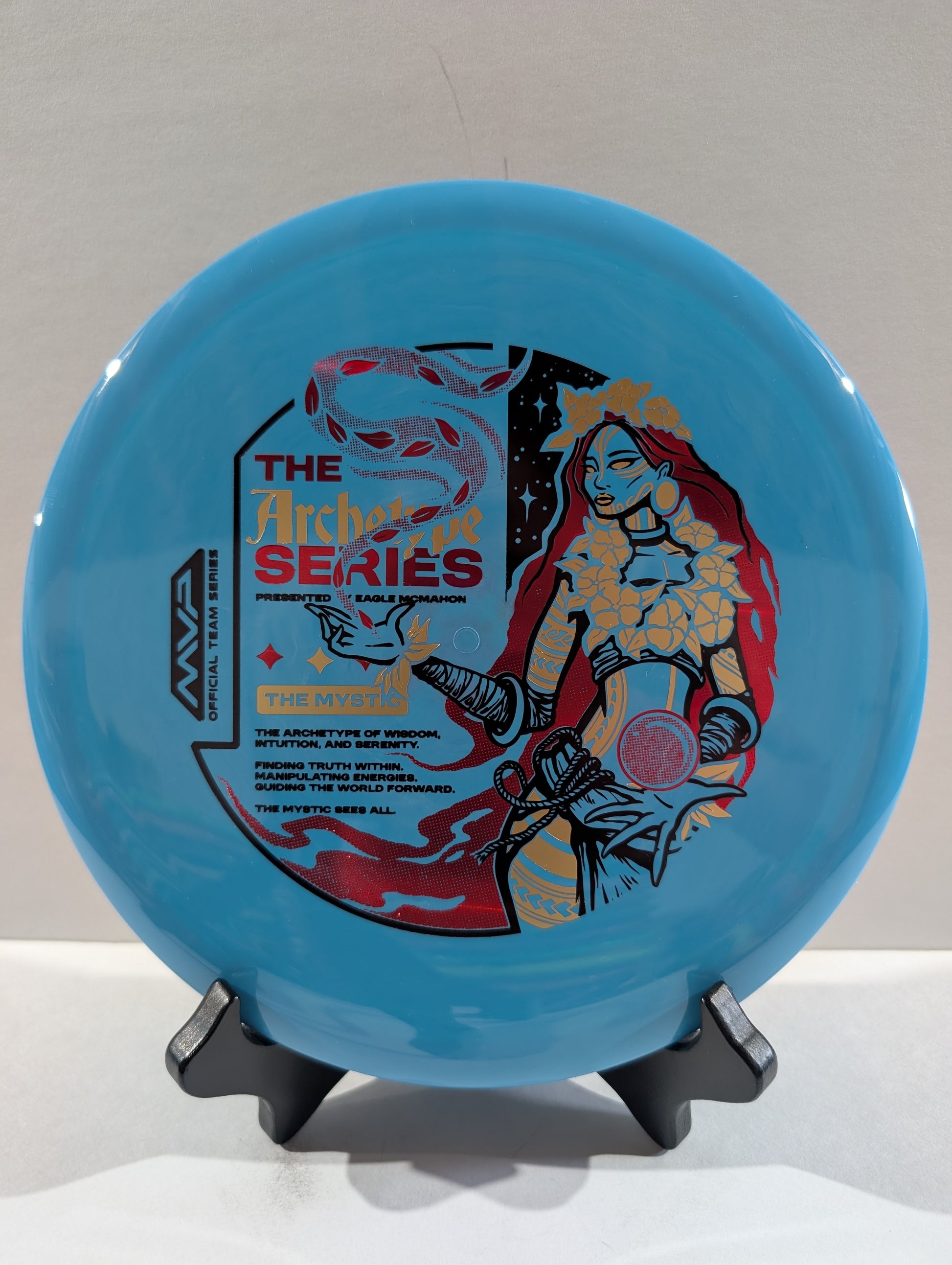 Blue disc with artistic design on a stand against a gray background