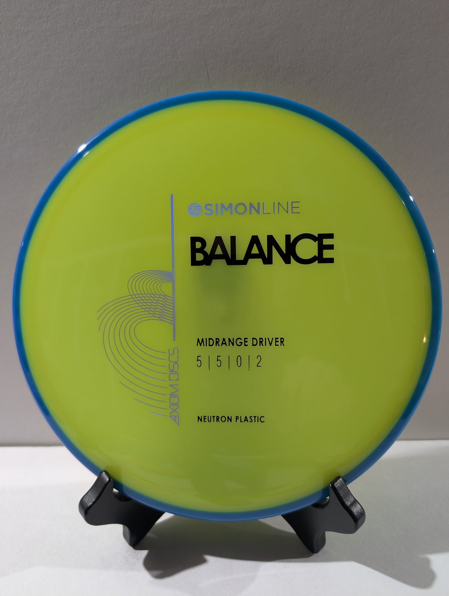 yellow disc with blue rim on a stand against a gray background