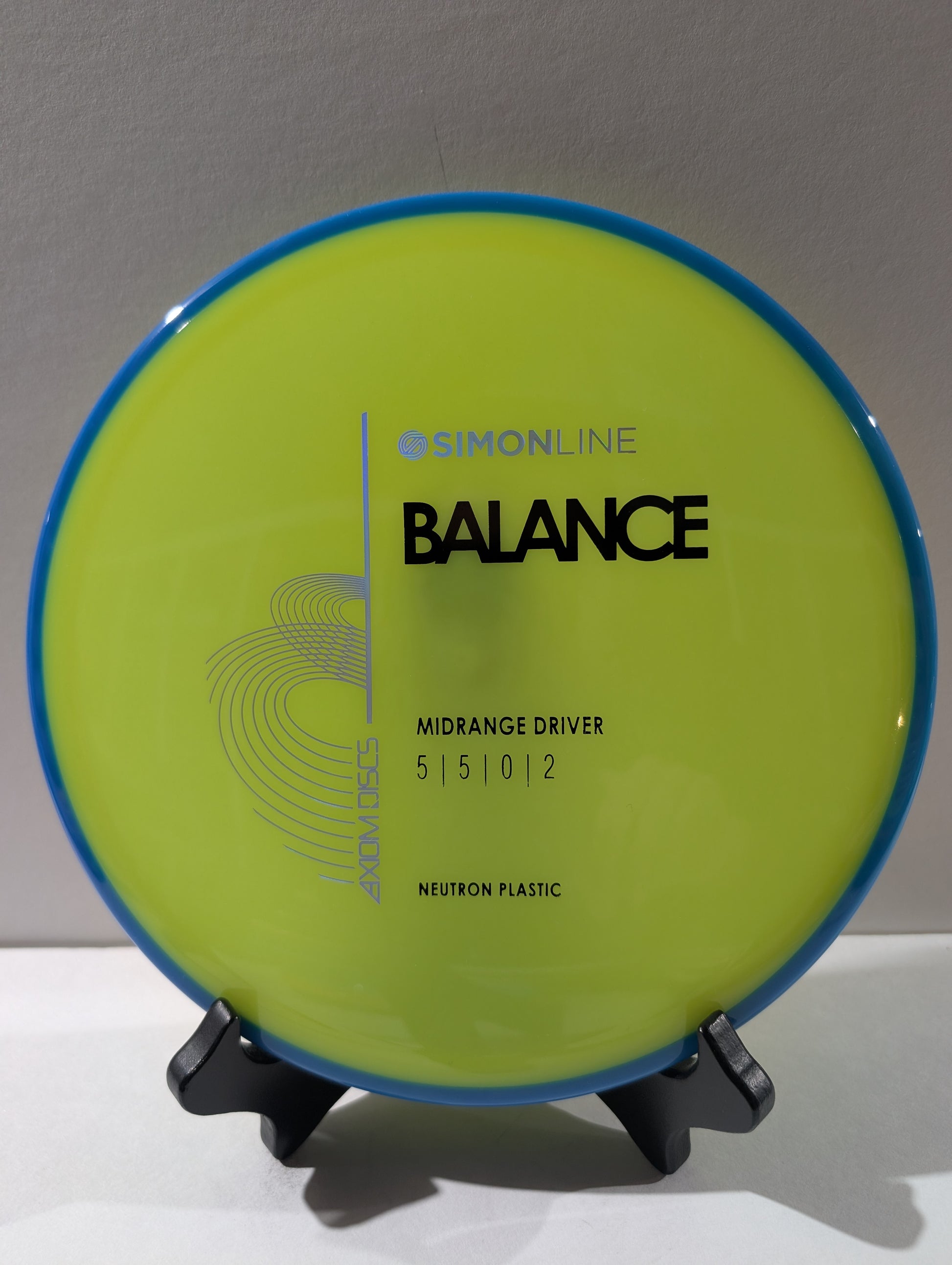 yellow disc with blue rim on a stand against a gray background