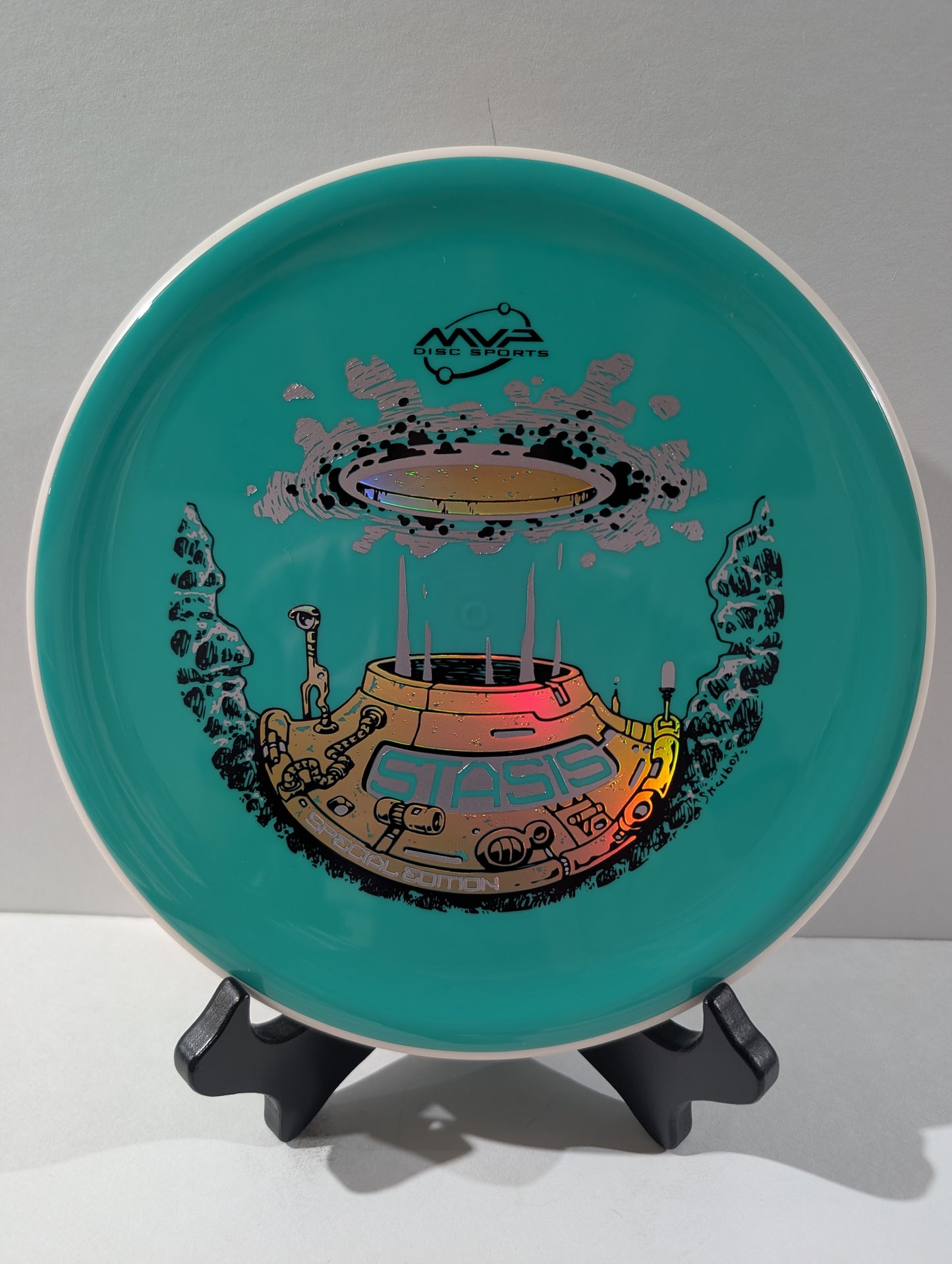Teal disc with a space-themed design on a stand against a gray background