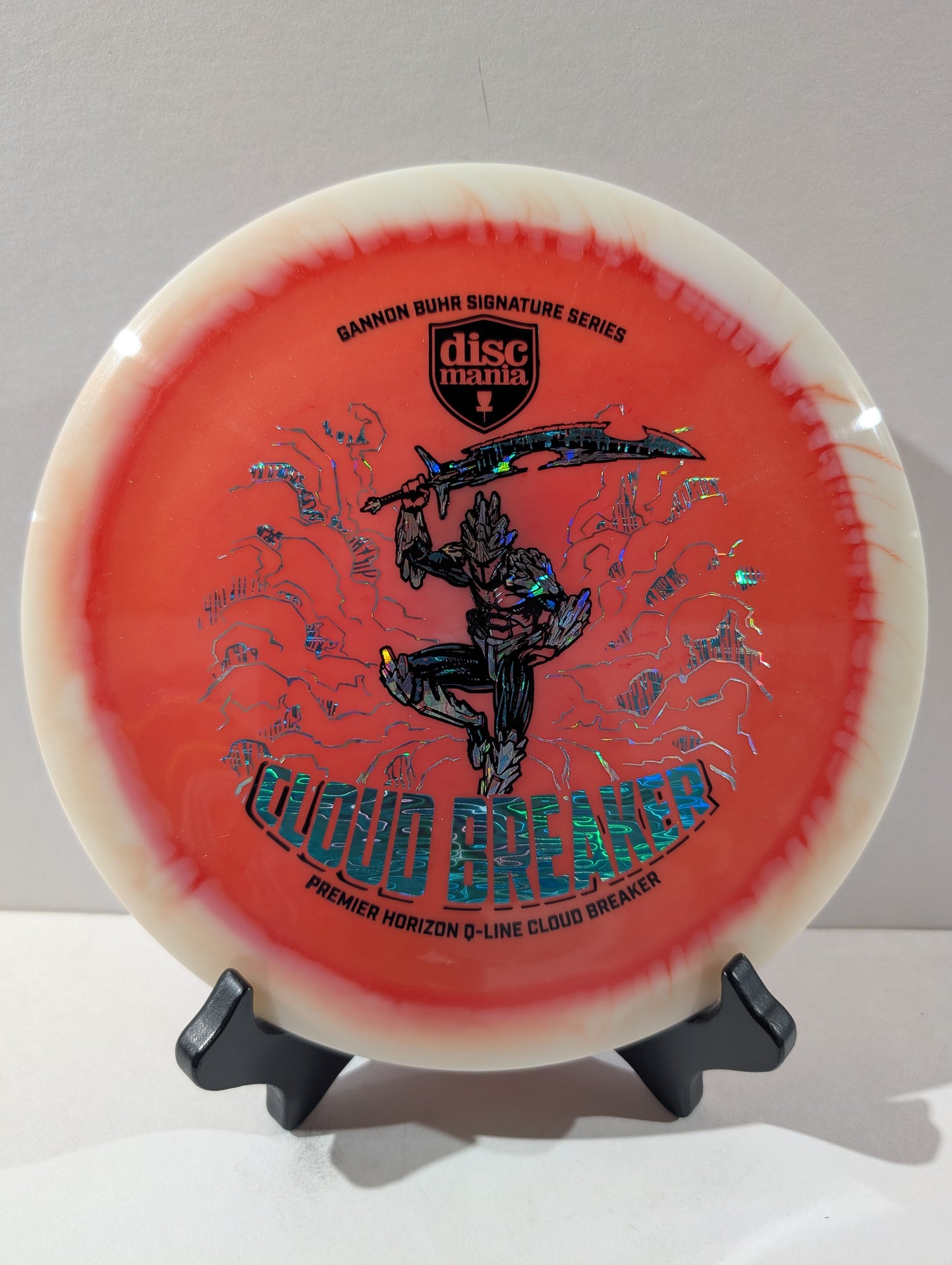 Disc golf disc with 'Cloud Breaker' branding on a stand against a gray background