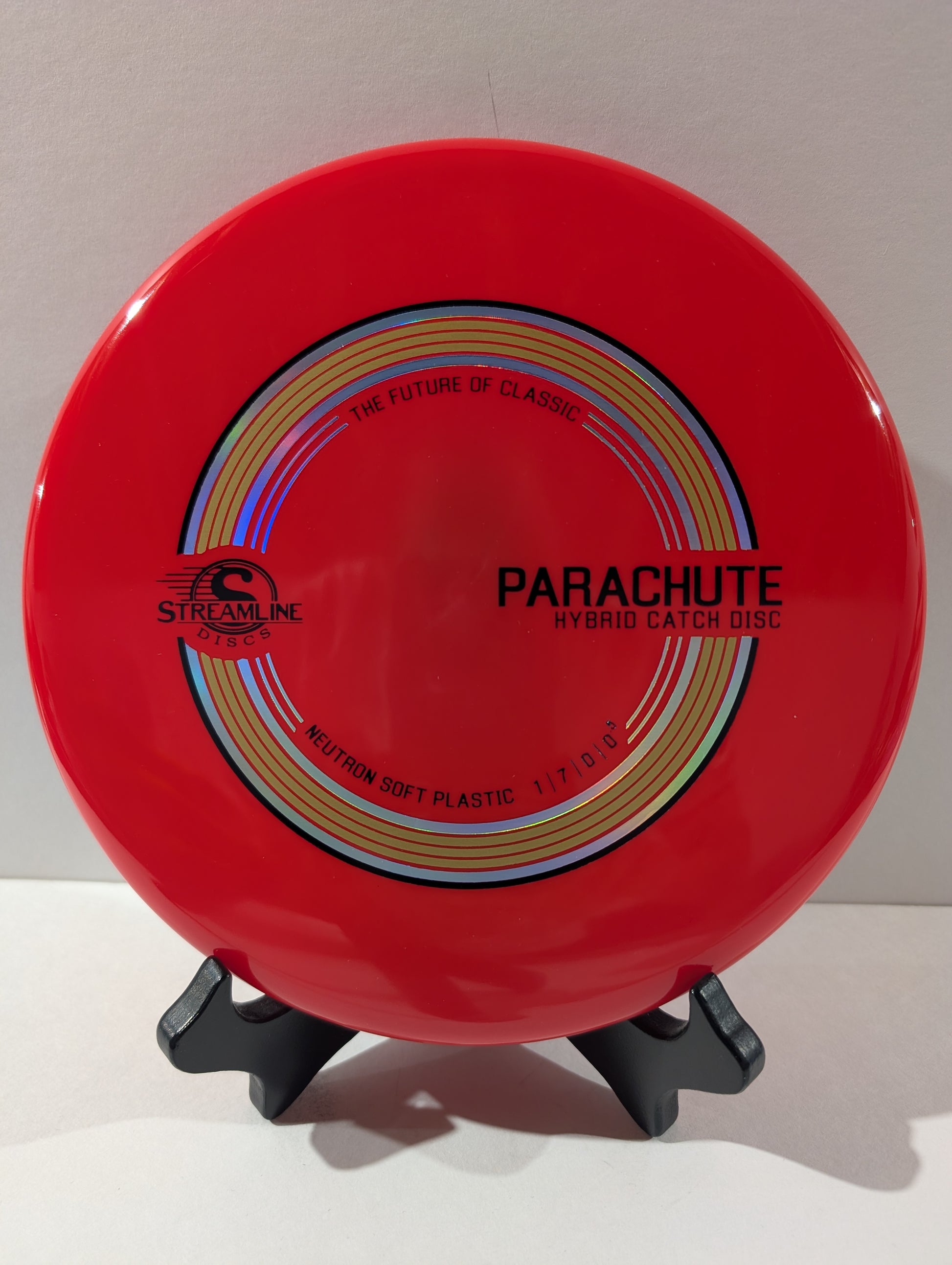 Red disc with 'Parachute' branding on a stand against a white background