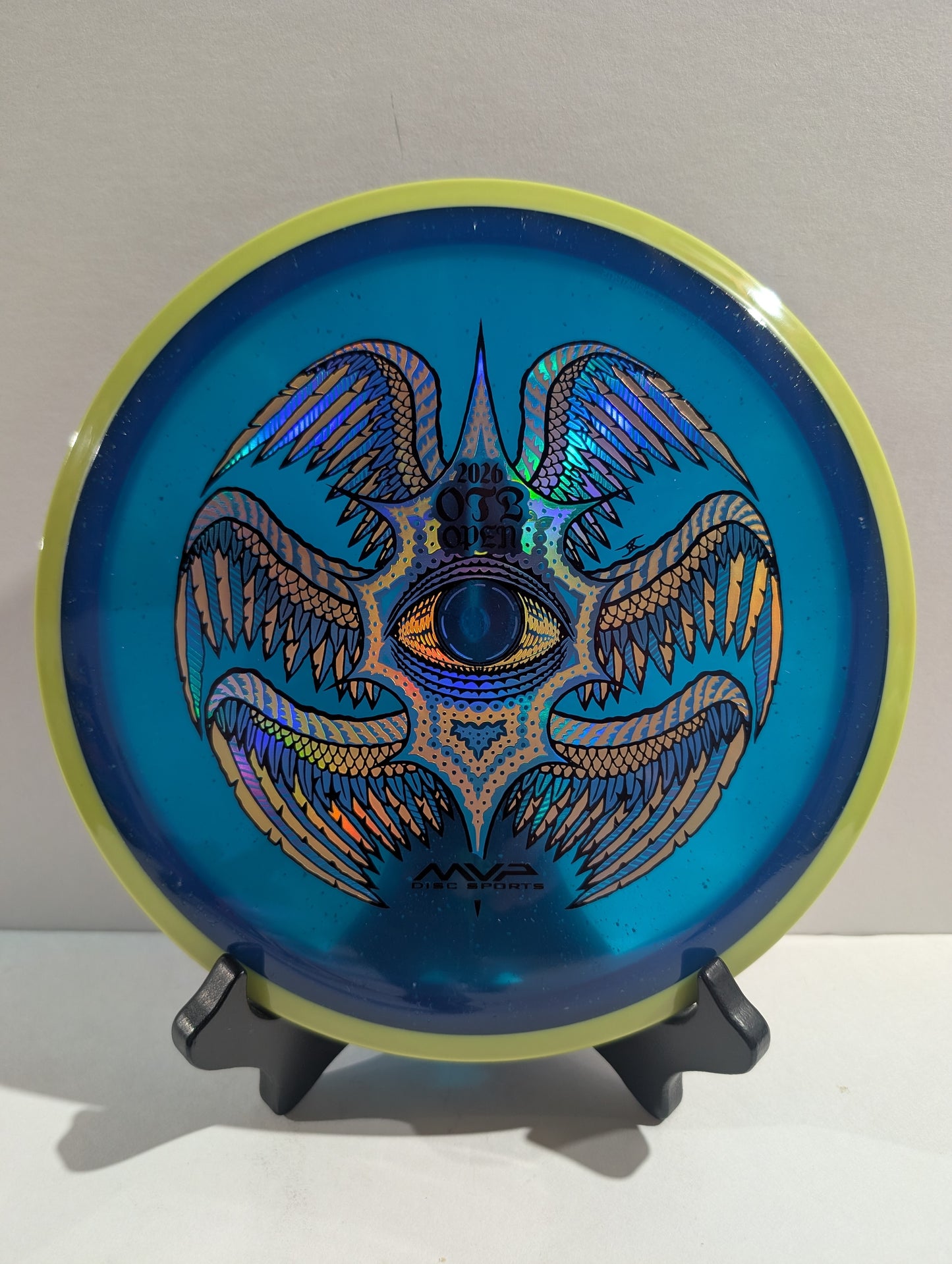 Blue disc with a decorative design on a stand against a white background
