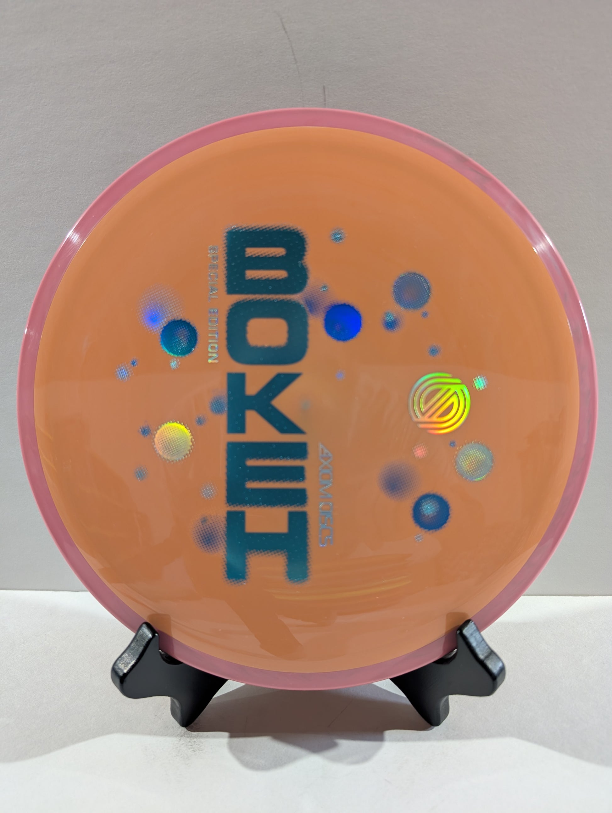 Disc golf disc with 'Bokeh' branding on a stand against a neutral background