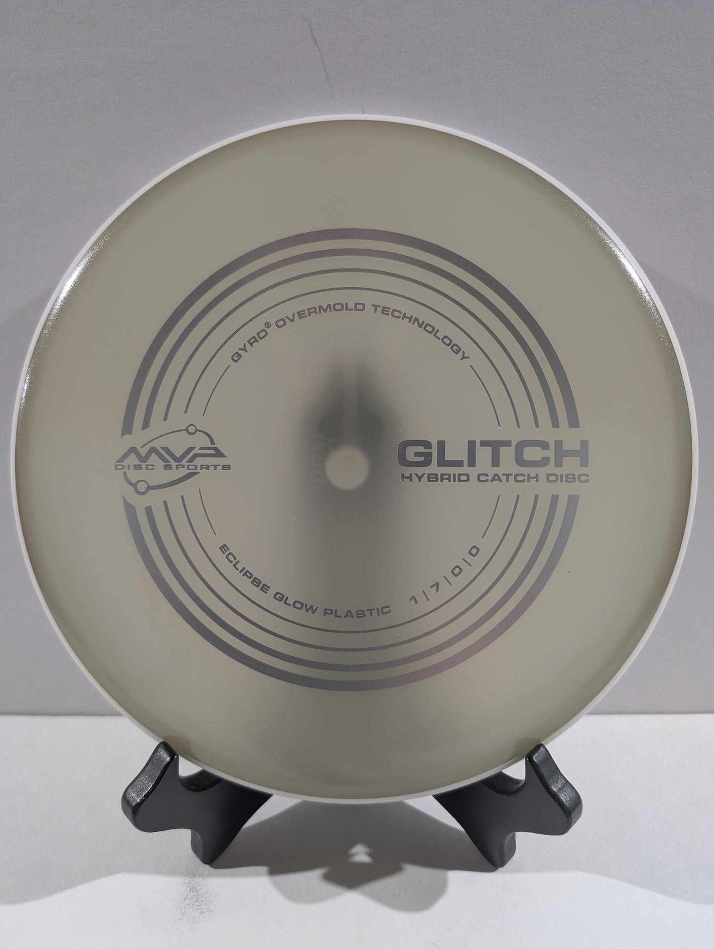 Disc golf disc with 'MVP' branding on a stand against a white background