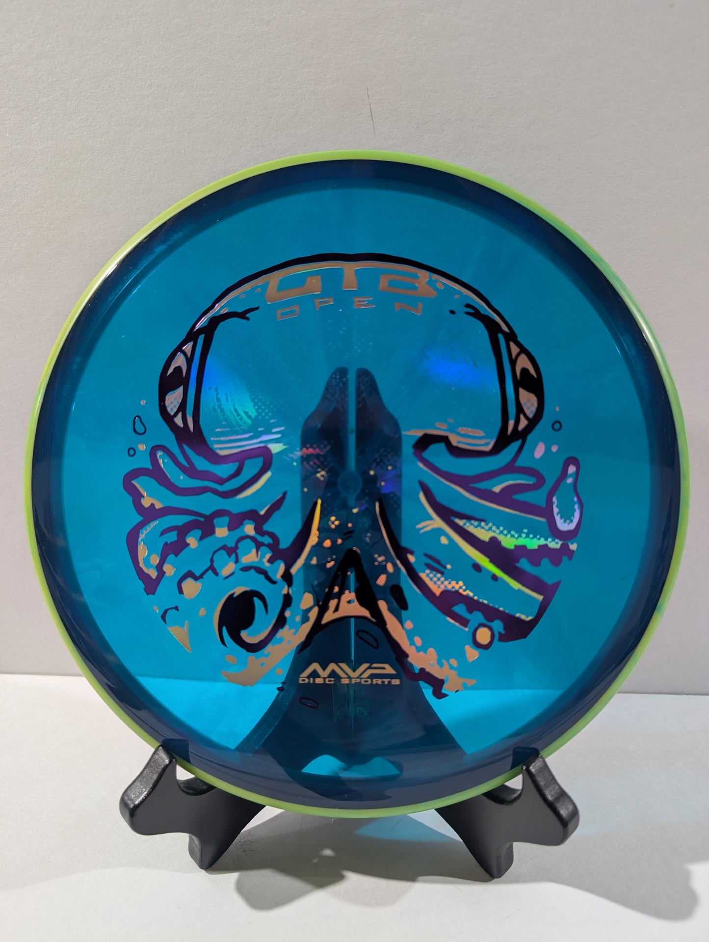 Blue and green disc golf disc on a stand with MVP Disc Sports branding.