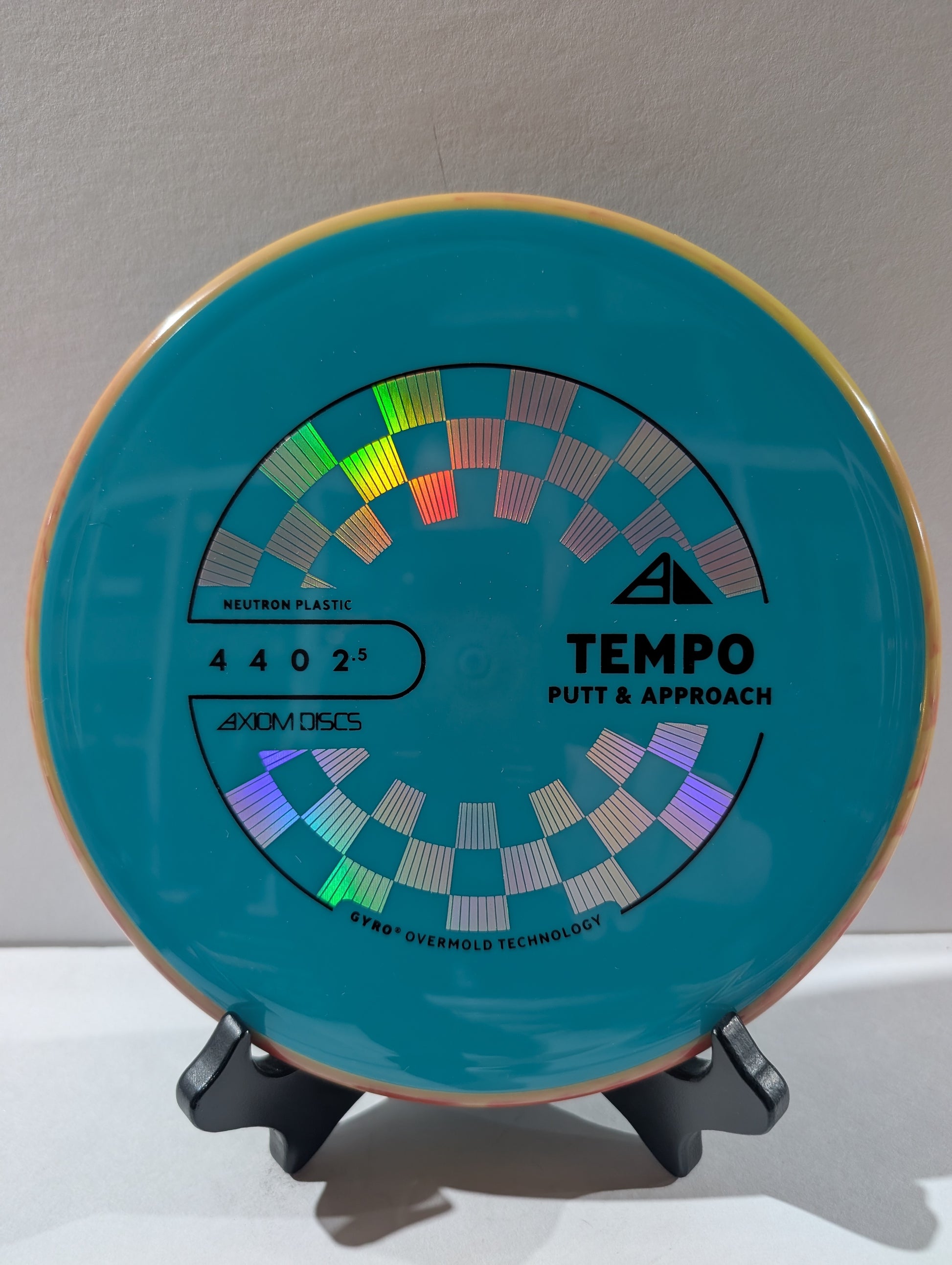 Blue disc golf putter with branding on a stand against a neutral background