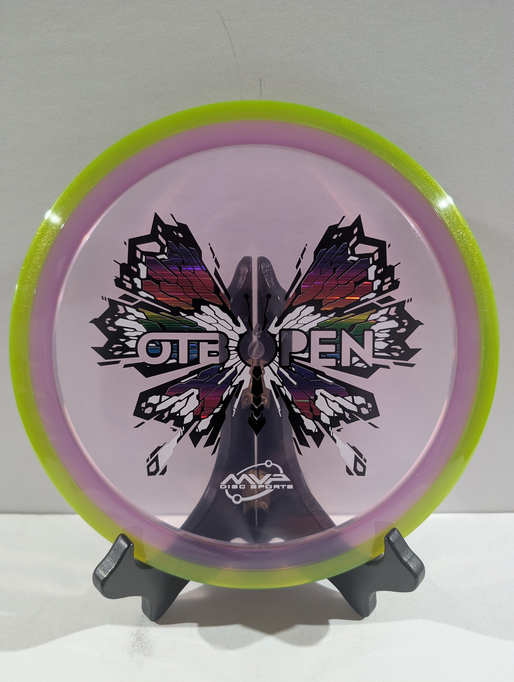 Disc with butterfly design and 'OTB Open' text on a stand against a white background