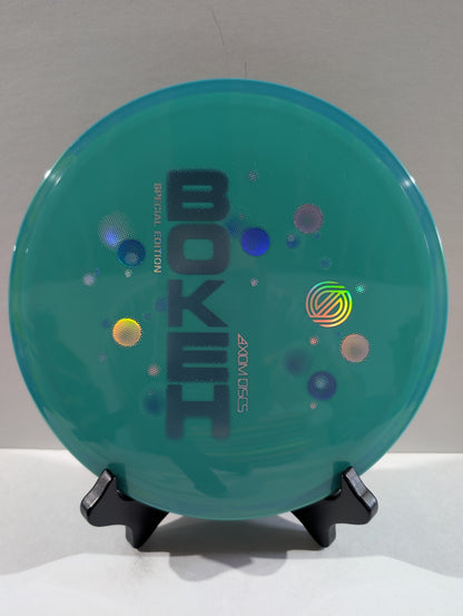 Teal disc with 'Bokeh' branding on a stand against a gray background