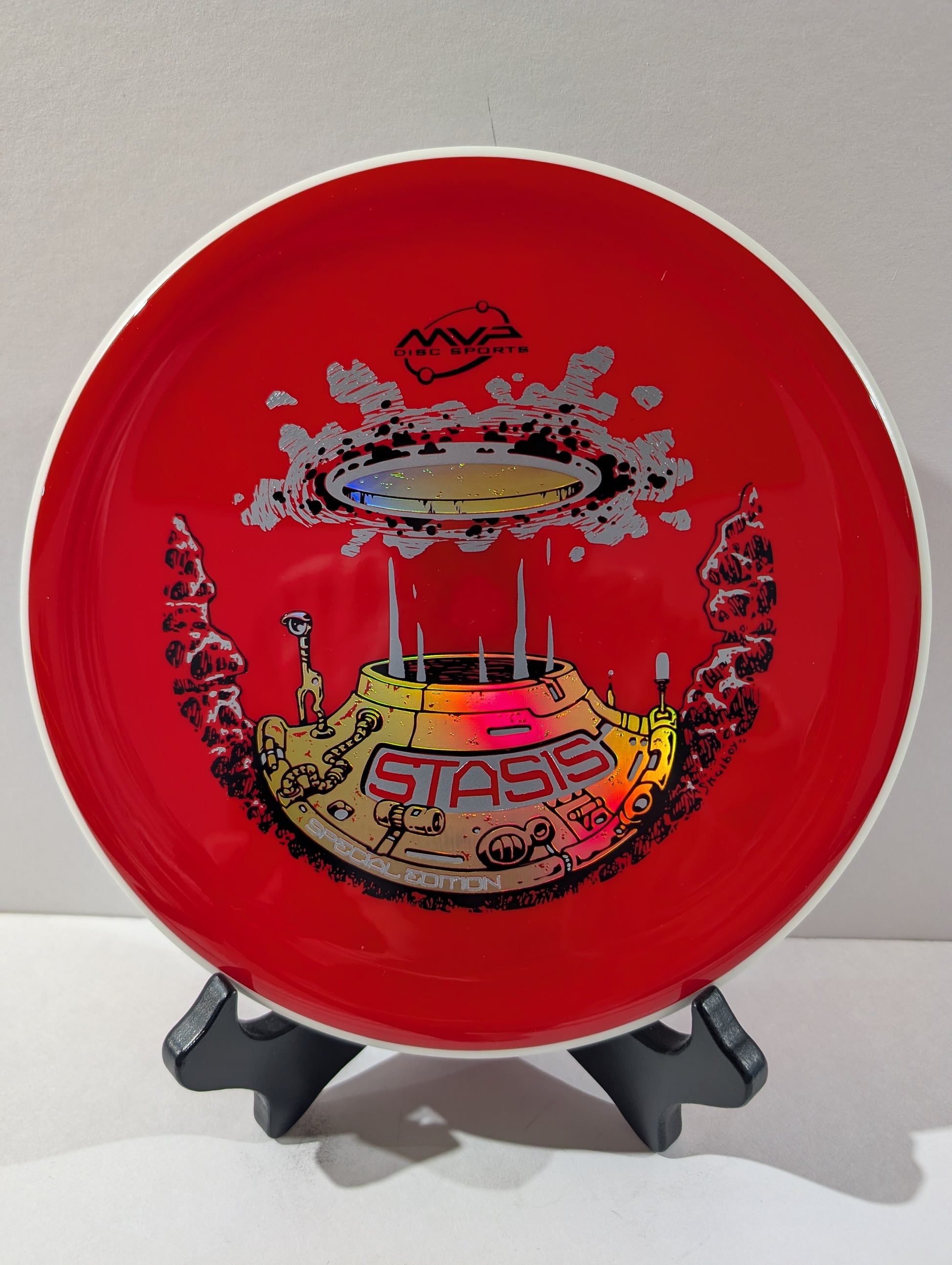 Red disc with a colorful design on a stand against a white background