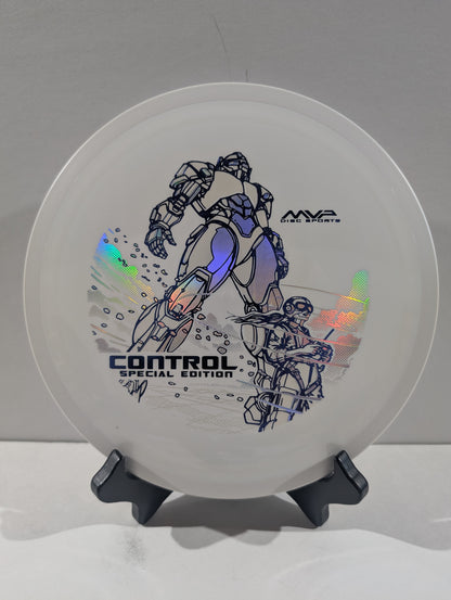 A white disc golf disc with a blue and black robot graphic, displayed on a black stand against a neutral gray background. The disc features holographic foil accents and text reading 'CONTROL SPECIAL EDITION' and 'MVP DISC SPORTS'.