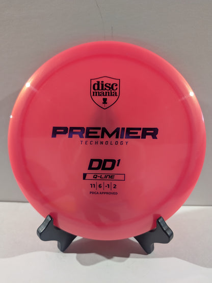 A bright pink Discmania Premier Technology DD1 Q-Line disc golf disc displayed on a small black stand against a plain light background.