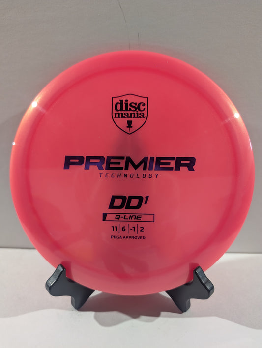 A bright pink Discmania Premier Technology DD1 Q-Line disc golf disc displayed on a small black stand against a plain light background.
