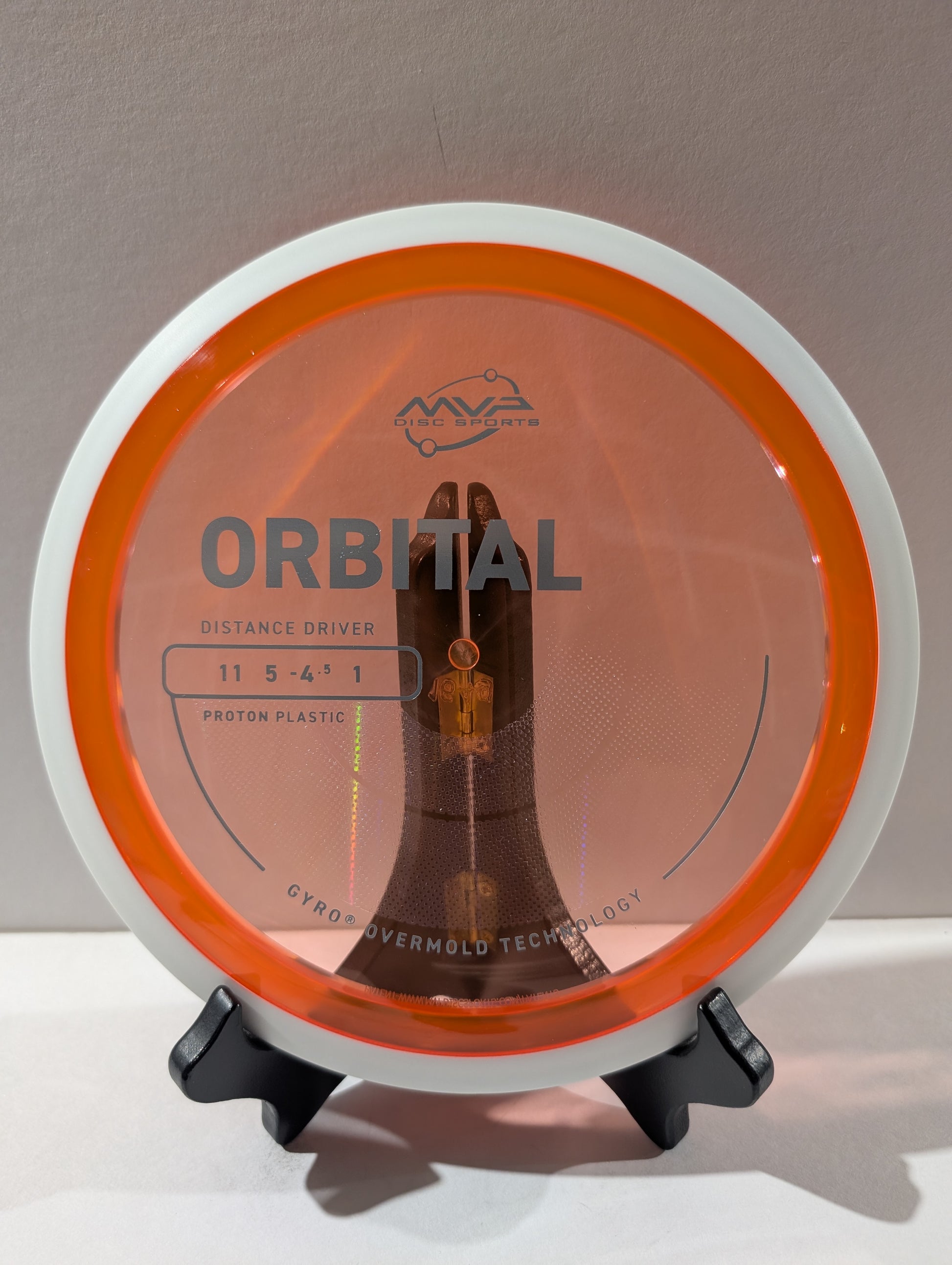 Disc golf disc with 'Orbital' branding on a stand against a neutral background