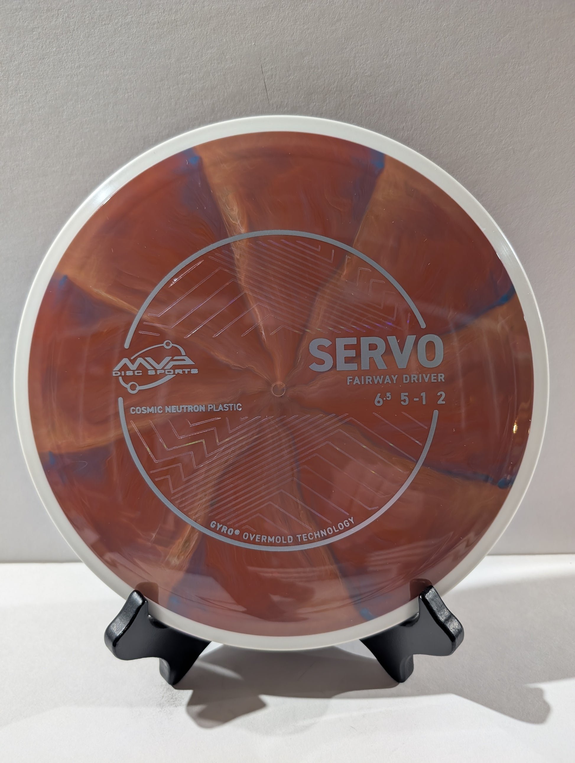 Disc golf disc with 'Servo' branding on a stand against a neutral background