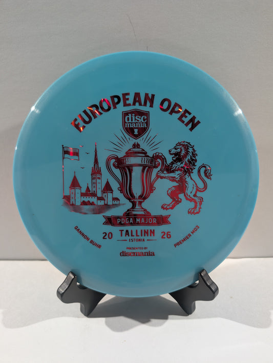 A light blue Discmania European Open disc golf disc displayed on a small black stand against a neutral light gray background.