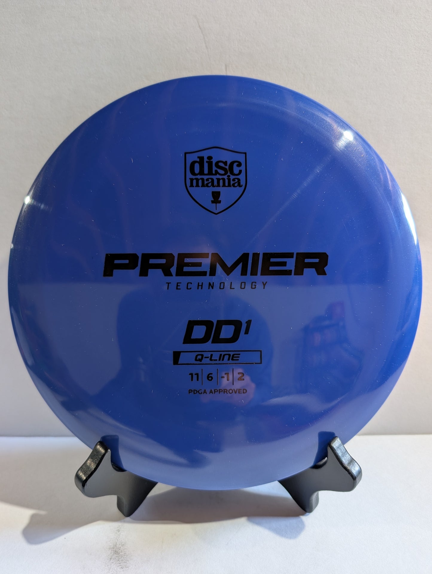 Blue disc with Discmania branding on a stand against a white background
