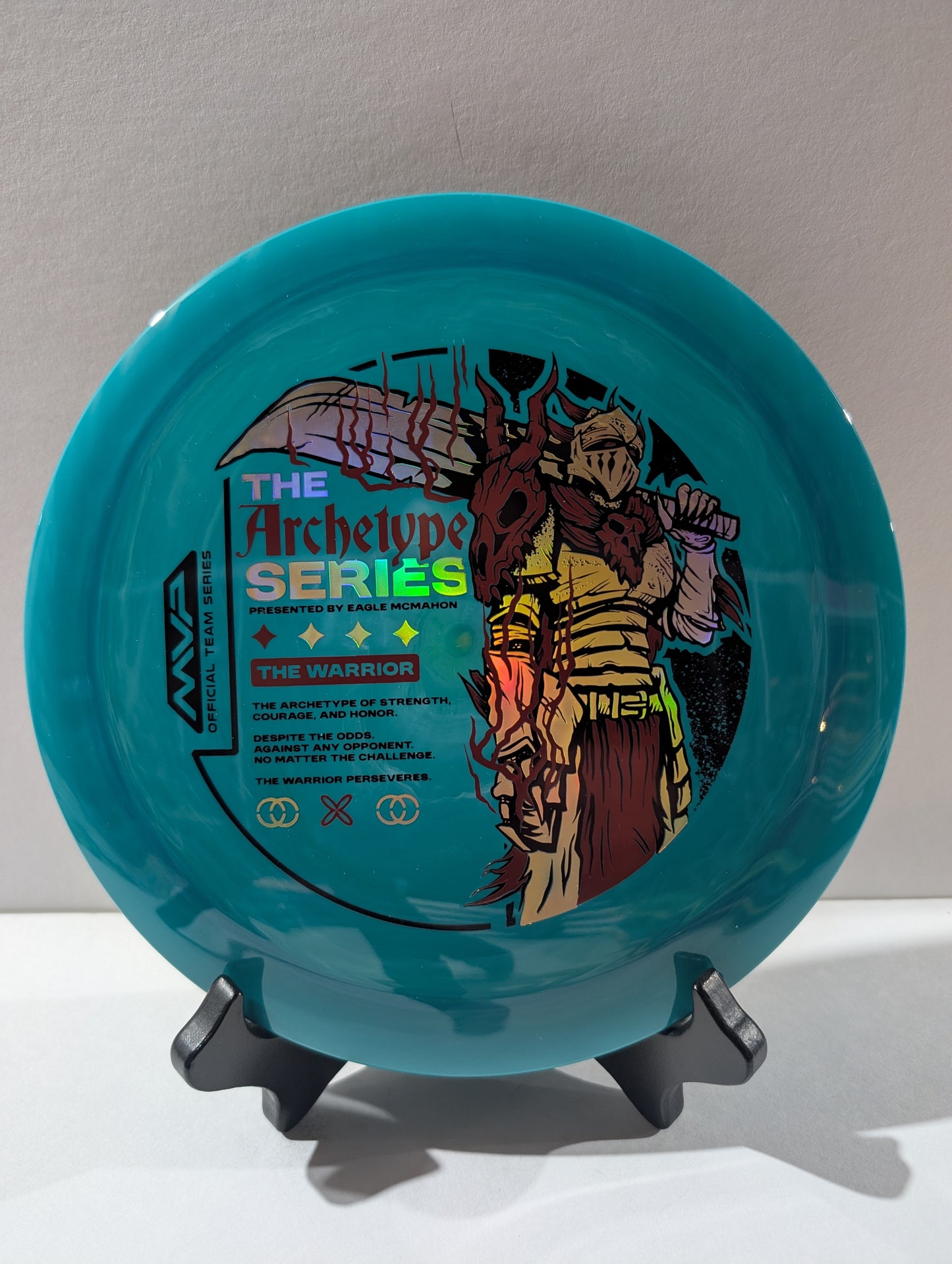 Blue disc with warrior design and text on a stand against a light gray background