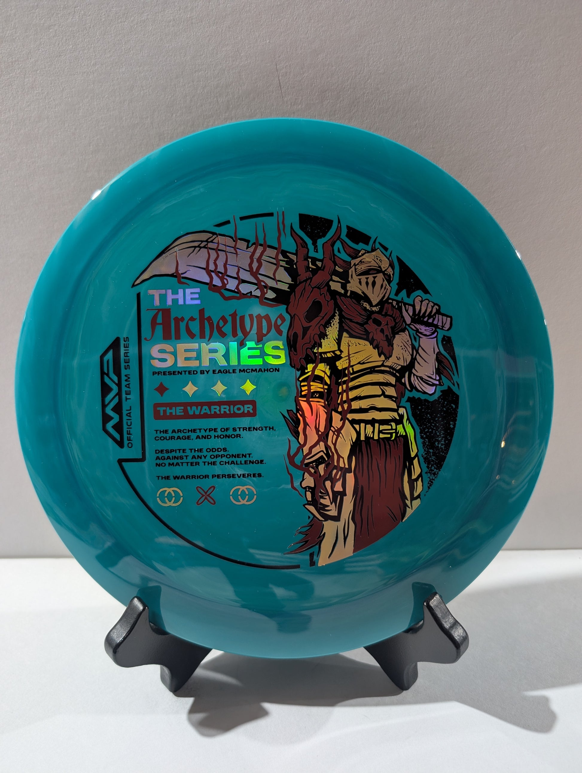 Blue disc with warrior design and text on a stand against a light gray background