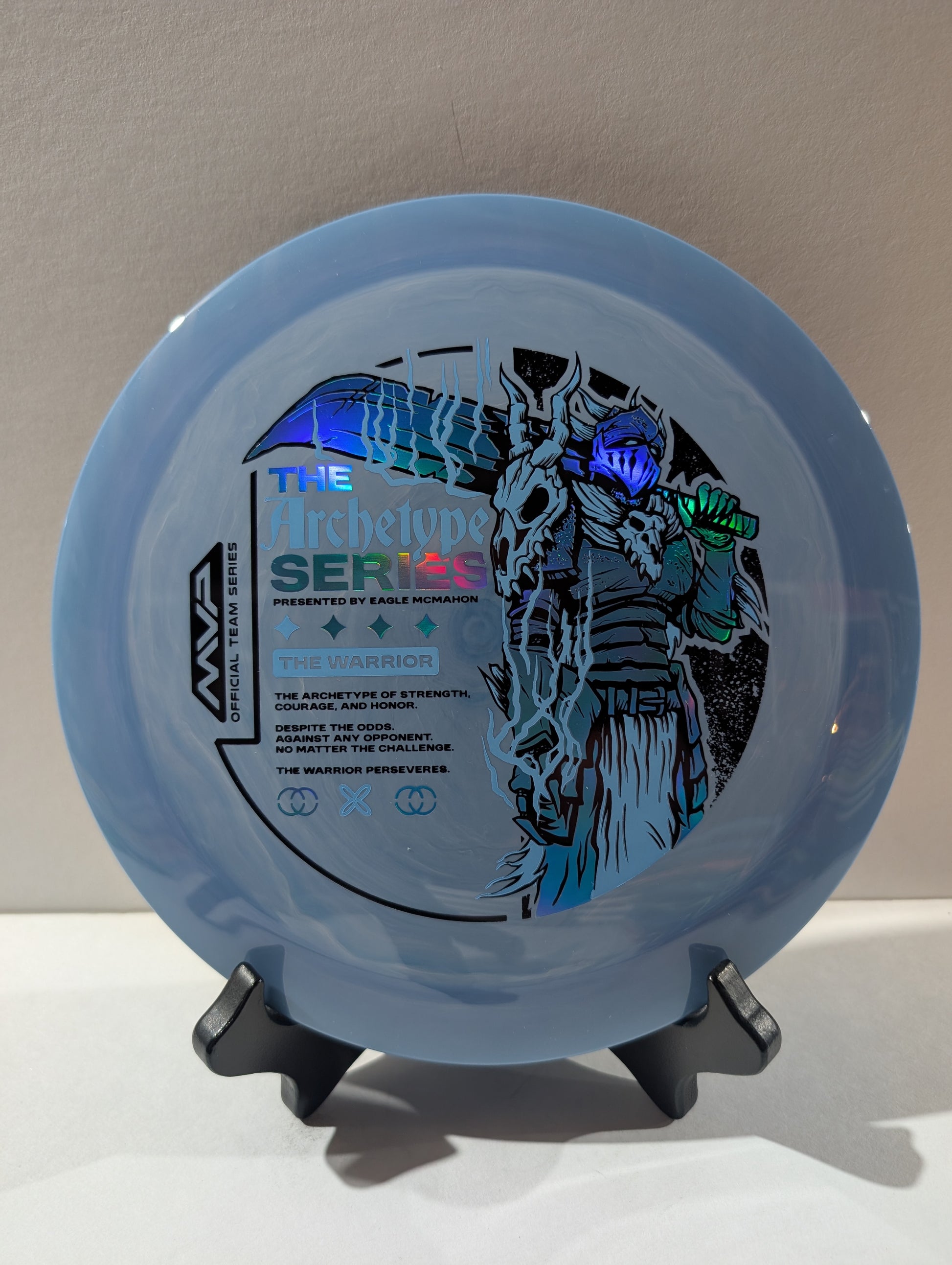 Disc with a character design and text on a stand against a neutral background