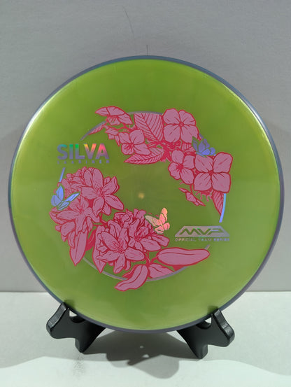 Green disc with pink floral design and 'Silva' branding on a stand against a white background