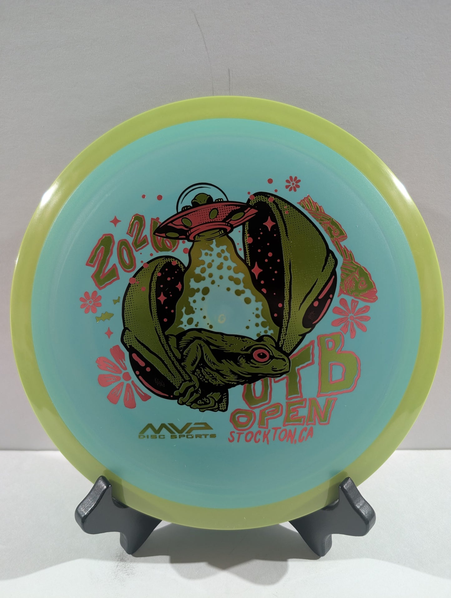 Disc golf disc with a design and text on a stand against a white background