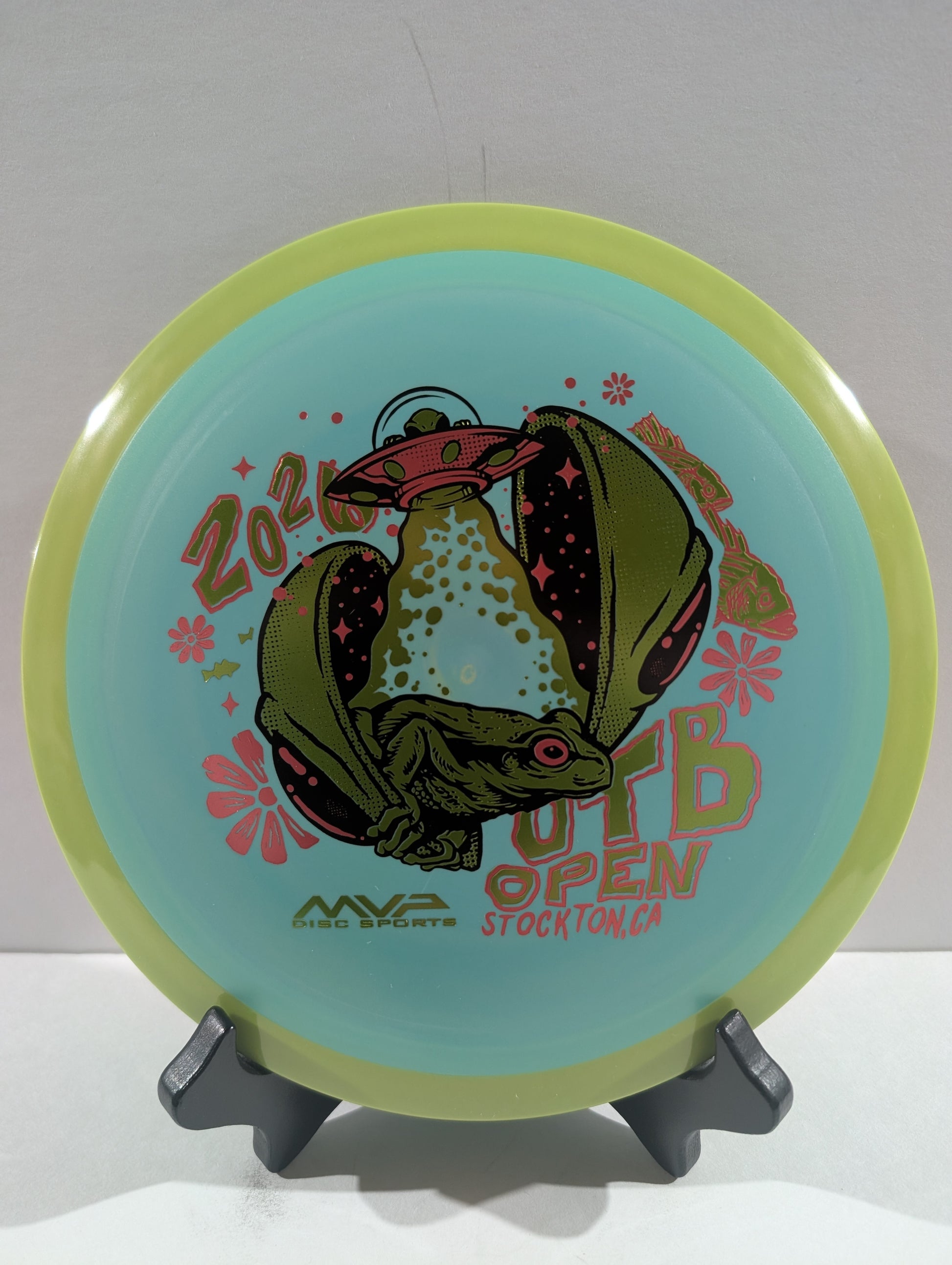 Disc golf disc with a design and text on a stand against a white background