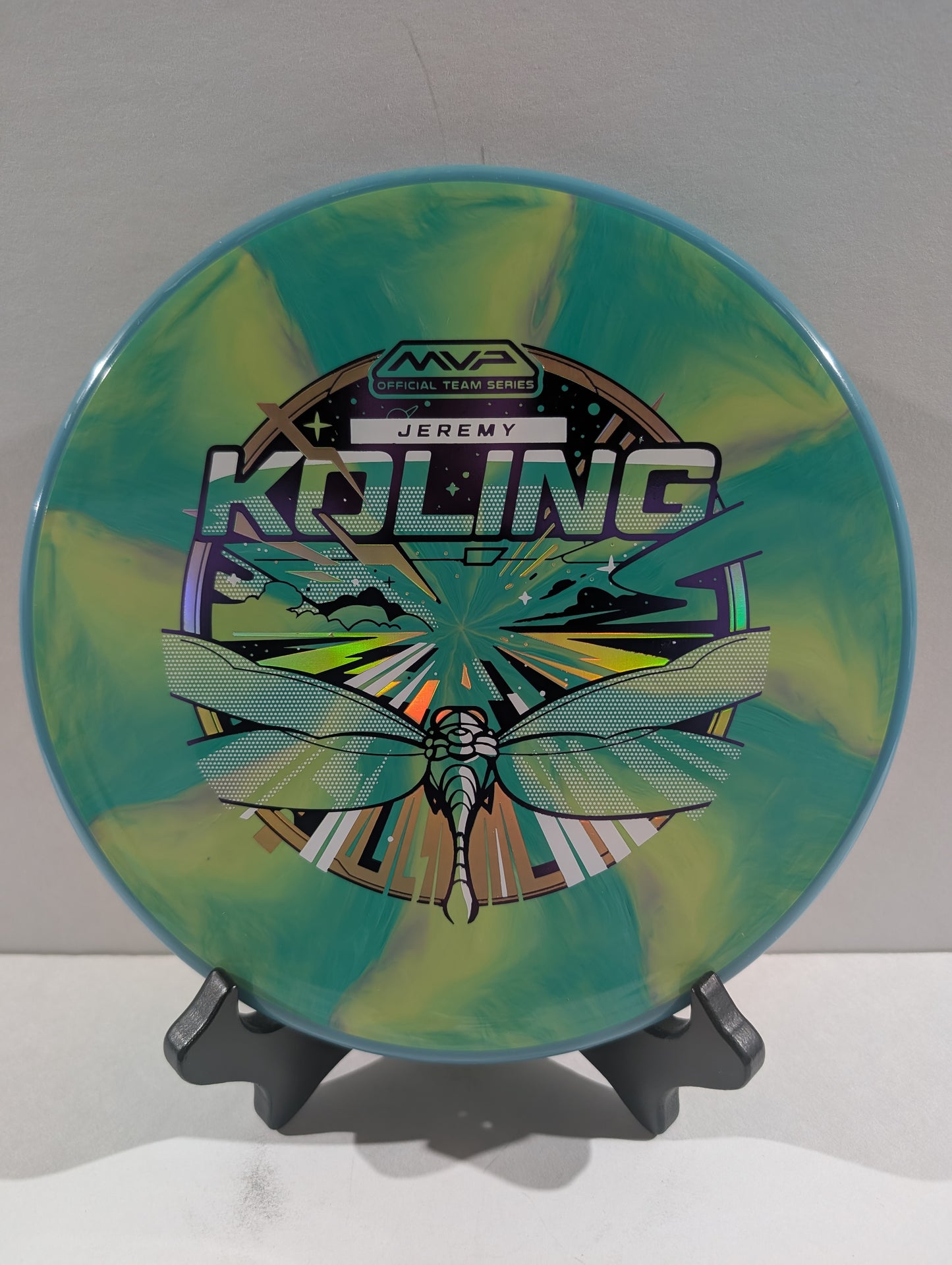 Disc golf disc with colorful design and branding on a stand against a white background