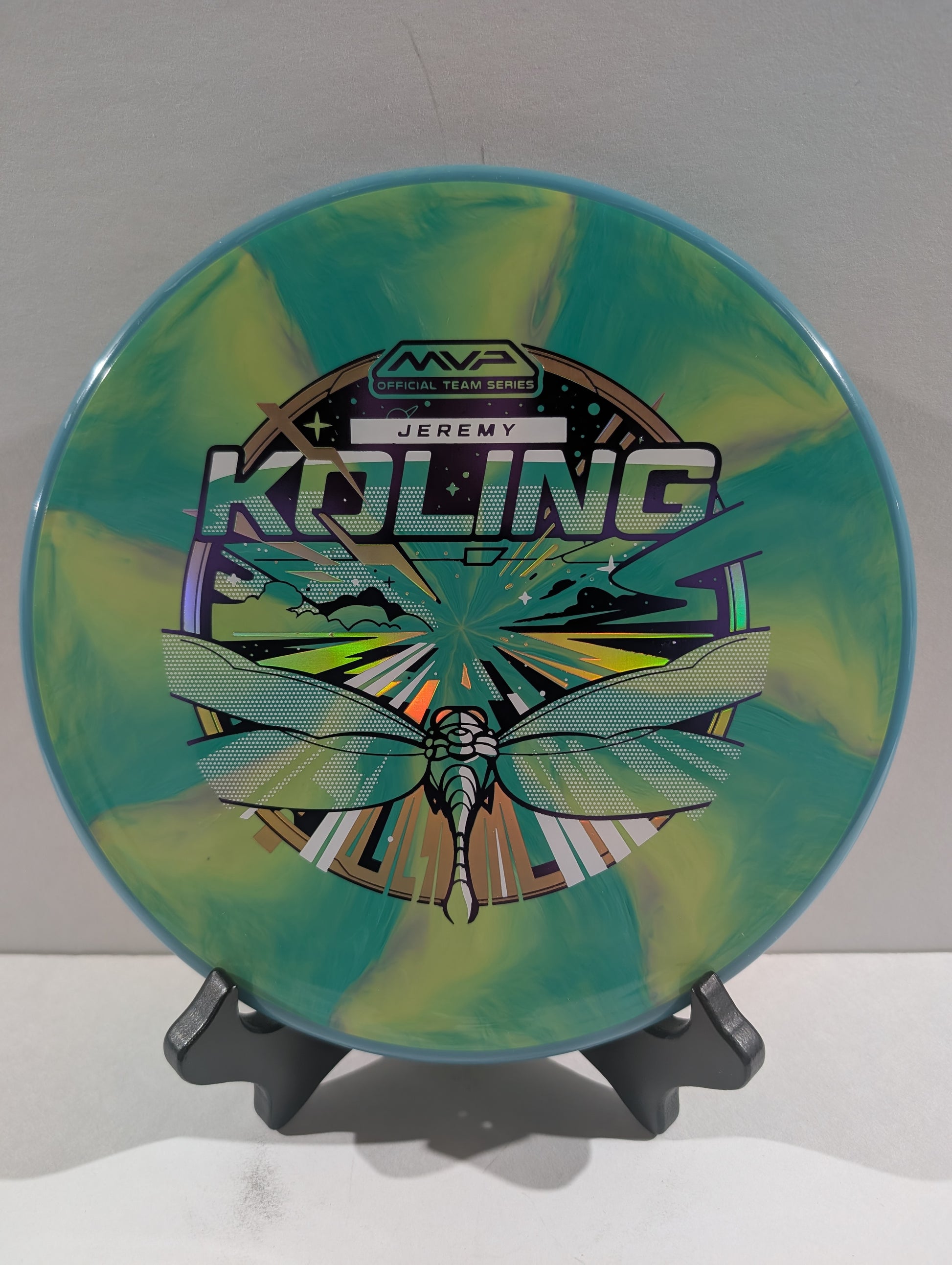 Disc golf disc with colorful design and branding on a stand against a white background