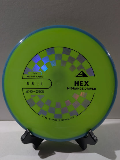 Green disc golf disc with branding on a stand against a neutral background