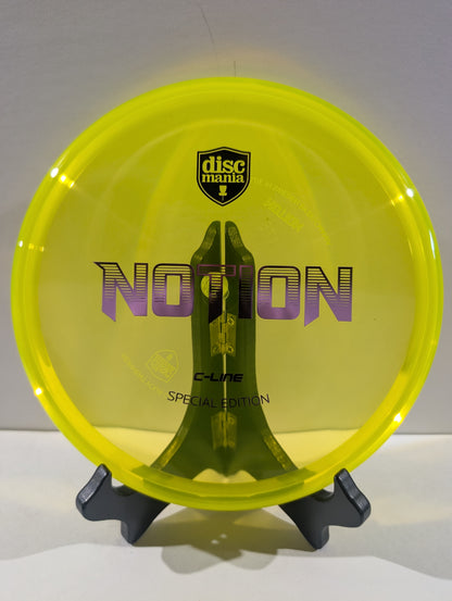 A translucent neon yellow Discmania C-Line Notion Special Edition disc golf disc displayed on a black stand against a neutral gray background.