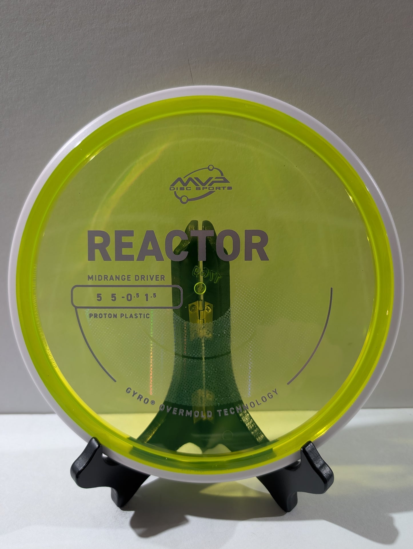 Disc golf disc with 'Reactor' branding on a stand against a gray background