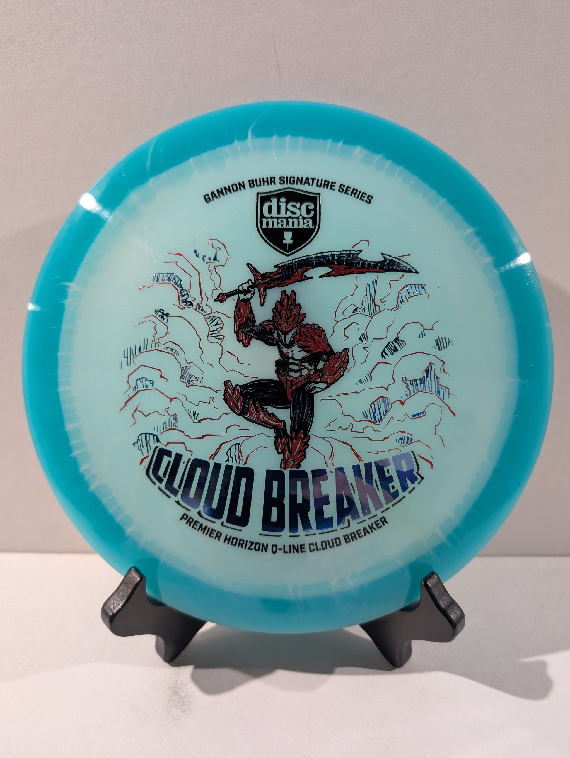 Disc golf disc with 'Cloud Breaker' design on a stand against a white background
