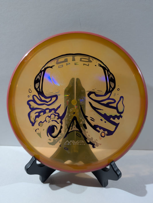 Orange disc golf disc with branding on a stand against a plain background