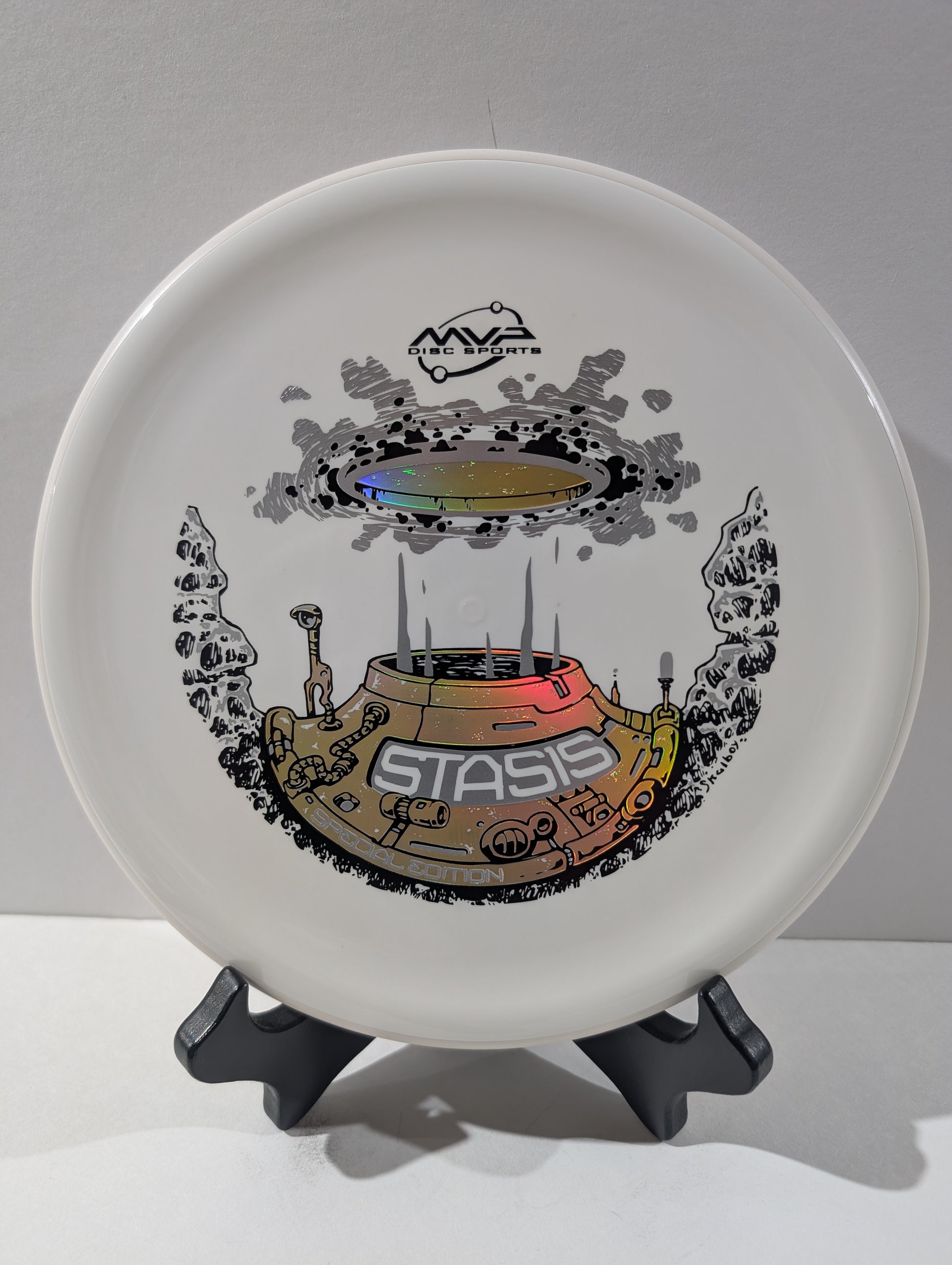 Disc with 'Stasis' design on a stand against a gray background