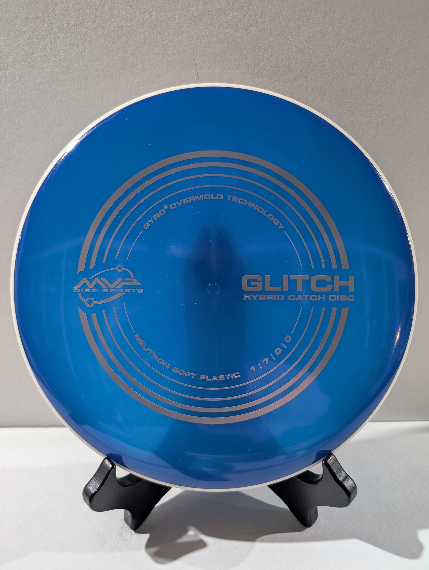 Blue disc with 'Glitch' branding on a stand against a gray background
