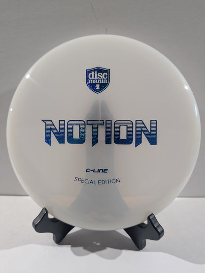 A white Discmania Notion C-Line Special Edition disc golf disc displayed on a small black stand against a neutral gray background.