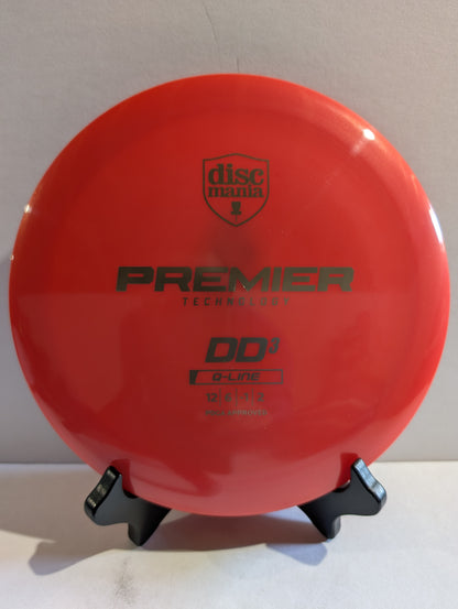 Red disc golf disc with Discmania branding on a stand against a neutral background