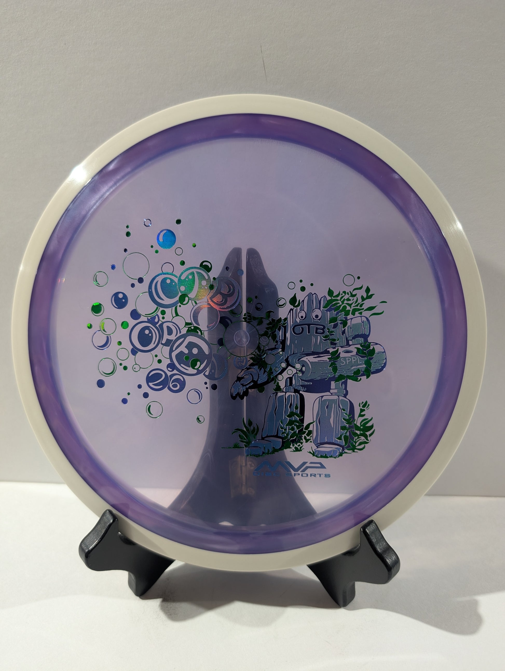 Purple disc with design and text on a stand against a gray background